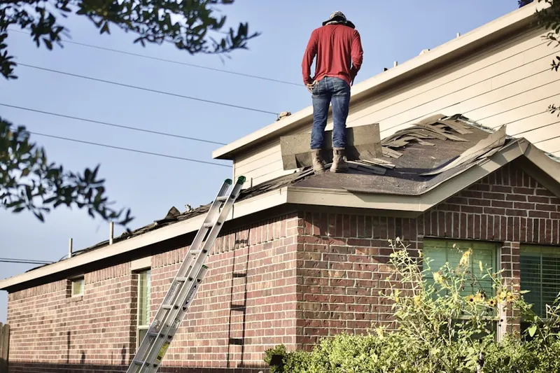 Professional roofer working on a residential roof in Newton Center